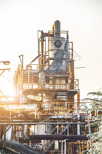 对日出天空背景的炼油厂形成工业区的输油管道和阀门进行工业近图片