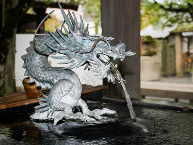 日本神社石龙雕像的细节与流水背景图片