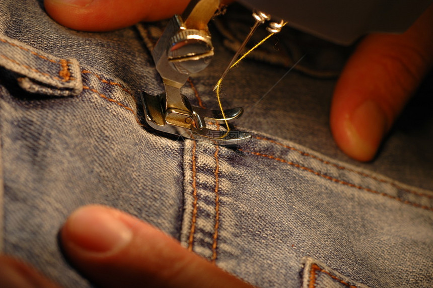 用缝纫机关闭双手纺织工业概念图片