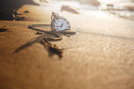 黄金沙滩在日出或夏日落时金沙滩的旧式袖手表图片