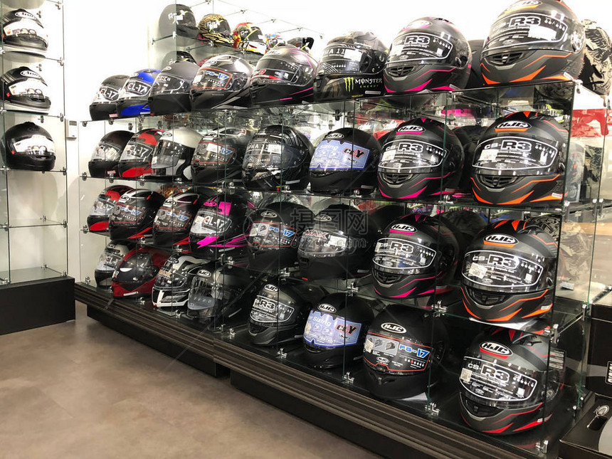 摩托车经销店陈列的各种颜色和形状的摩托车头盔图片