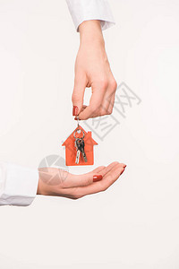女手握从孤立在白色房屋中的房子的钥图片