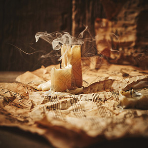 木制背景上带有蜡烛的老式音乐表图片