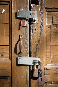 风化棕色门上的挂锁图片
