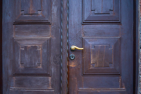 带锁的黄铜把手的旧木教堂门图片