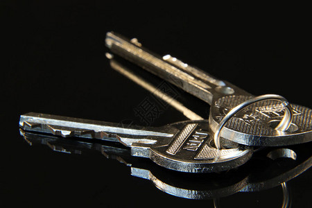 两把银钥匙用来打开由黑色背景金属戒指连图片