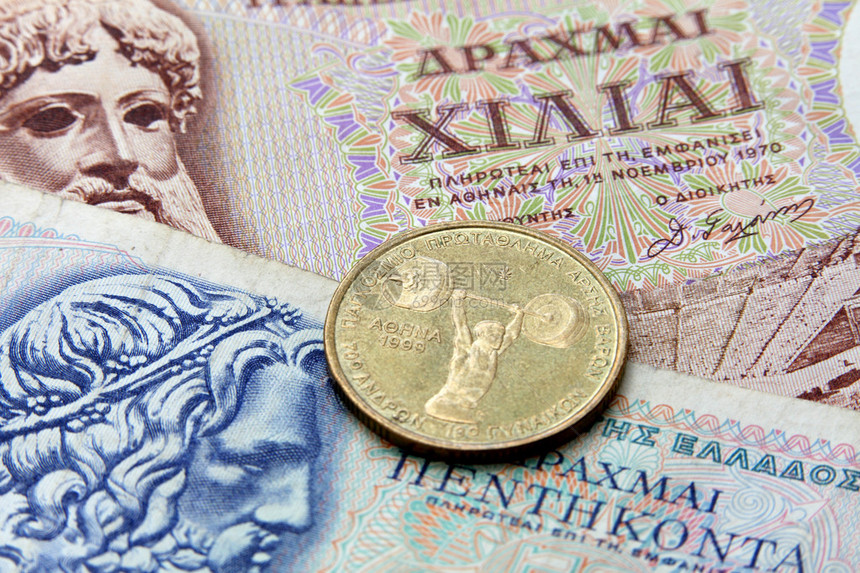 希腊德拉克马钞票和一枚纪念1999年在雅典举行的世界举重锦标赛的硬币2012年的希腊政界人士要避免重回德拉克马图片