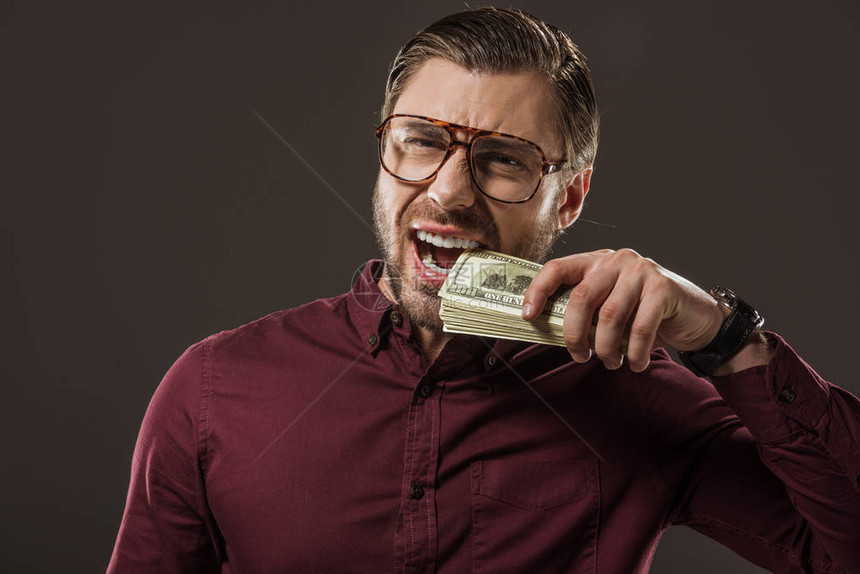 在眼镜里做情感生意的商人咬着美元钞票孤图片