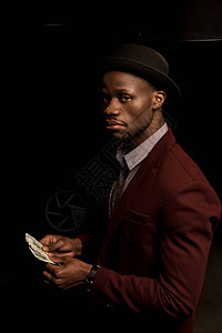 身戴帽子持有美元钞票的非洲有钱英俊富帅的美国男子图片