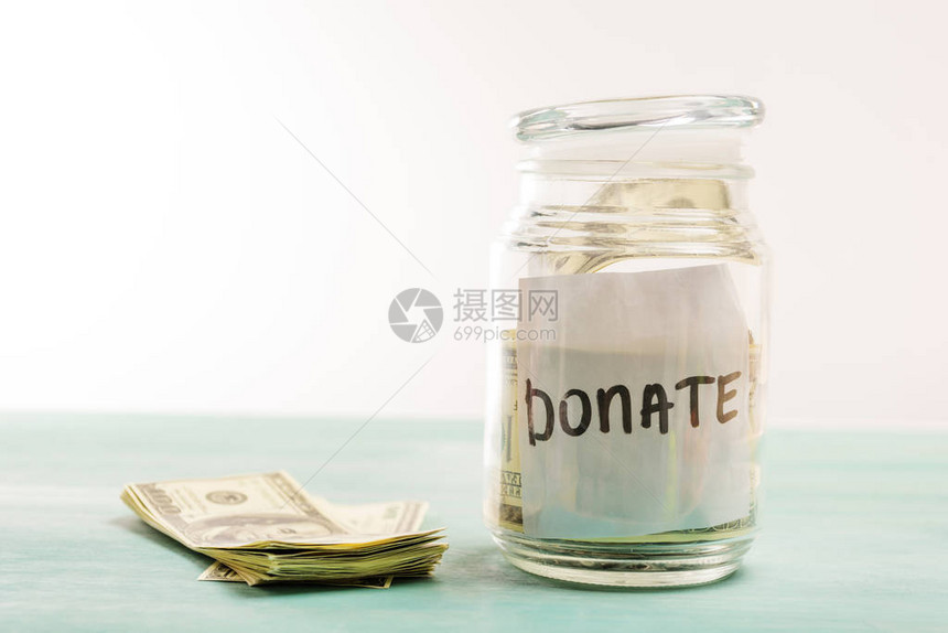 玻璃罐中美元钞票与捐赠信捐赠概图片