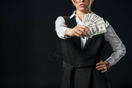 持有美元钞票孤立在黑纸币上的女商图片