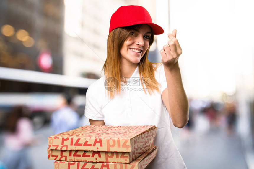 披萨交付妇女以无重点背景做出金钱姿态的比图片