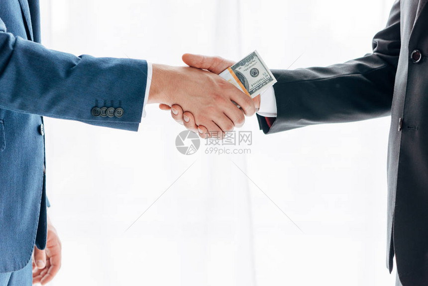 男人向商业伙伴行贿并与白人握手的剪影图片