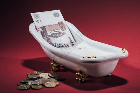 关于红洗钱概念的小型浴缸和硬币中俄罗图片