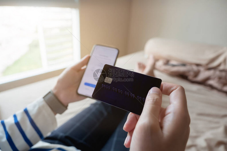 网上购物支付妇女手拿着智能手机和信用卡图片