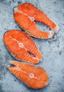新鲜的鲑鱼片切平躺在破旧的金属背景上新鲜的三文鱼片在新鲜的海鲜摊图片