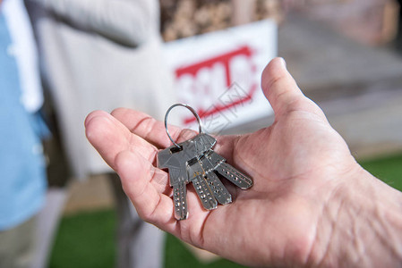 销售商持有新房钥匙出售房屋背景图片