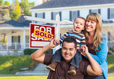 快乐混合种族青年家庭在出售房地产标志和房屋售房图片