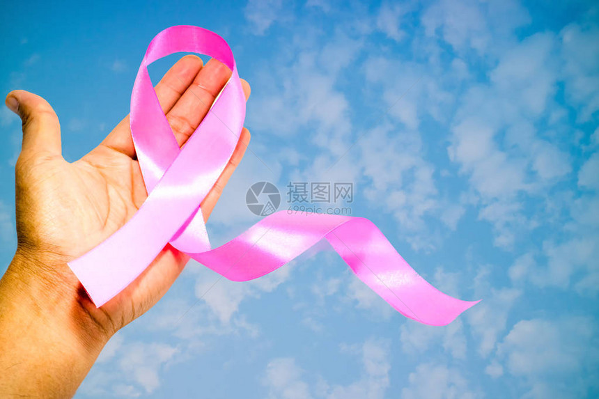 手上有粉色布料丝带模糊的天空背景运动的概念图片