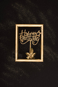 黑色表面金色快乐生日标志植物和照片背景图片