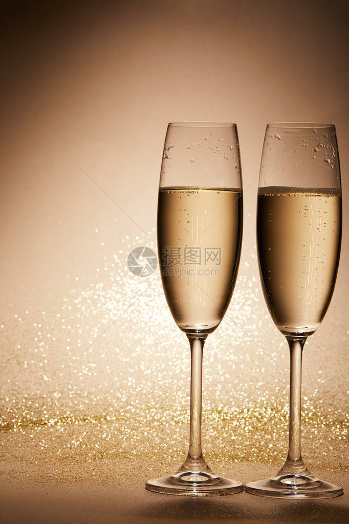 两杯香槟茶桌上有亮光圣诞概念图片