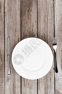 木桌上排列的空盘子叉子和刀子的顶视图背景图片
