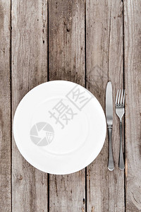 木桌上排列的空盘子叉子和刀子的顶视图背景图片