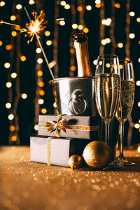 桶中的香槟礼物和圣诞灯饰在花环图片