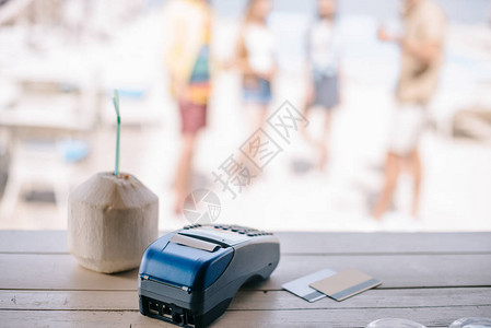 在沙滩酒吧的柜台收看有饮用稻草的夏鸡尾酒和信用卡图片