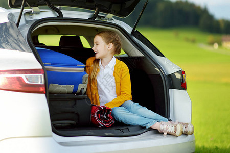 可爱的小女孩准备和她的父母去度假孩子在公路旅行前在车里放松带图片