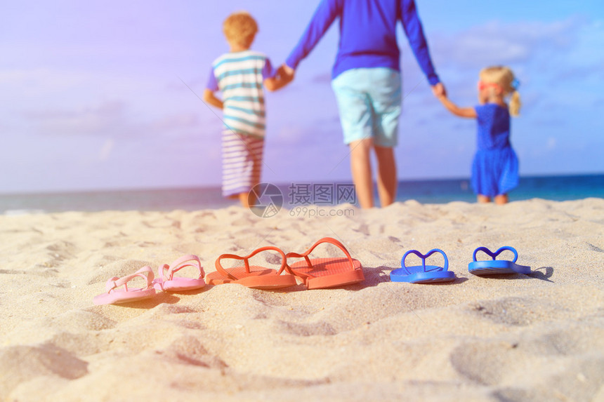 父亲和儿子与女儿在沙滩上散步图片