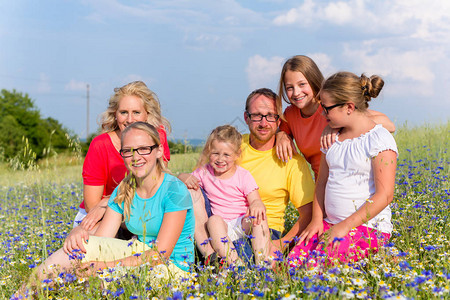 家庭坐在草地上的鲜花妈图片