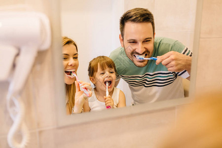 幸福的家庭在洗手间镜子前刷图片
