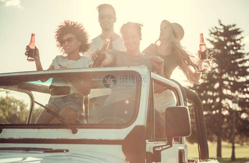 快乐的年轻人在阳光天气下乘车旅行时图片