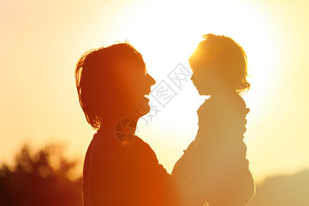 父亲和小女儿在日落时的休图片