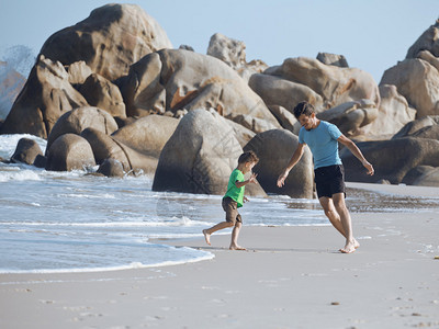 父亲和儿子一起走在海边图片