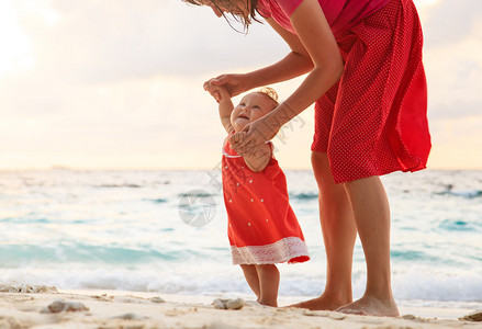 走在沙滩上的母亲和小女儿图片