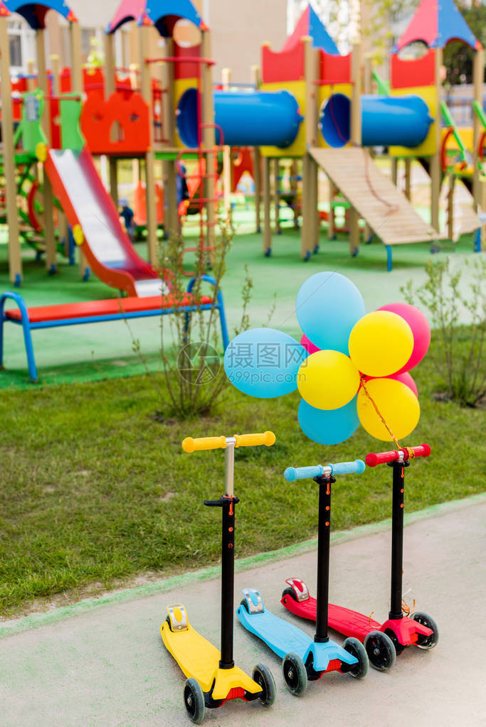 3辆儿童式脚踏车在操场用彩色气球和多彩图片