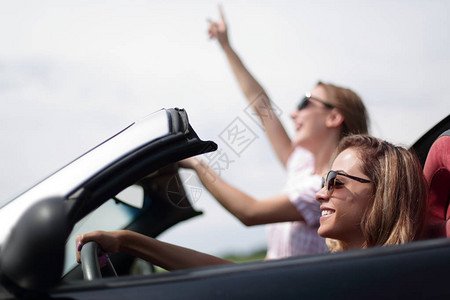 2名年轻女子乘坐敞篷车旅行时髦的生活方式图片