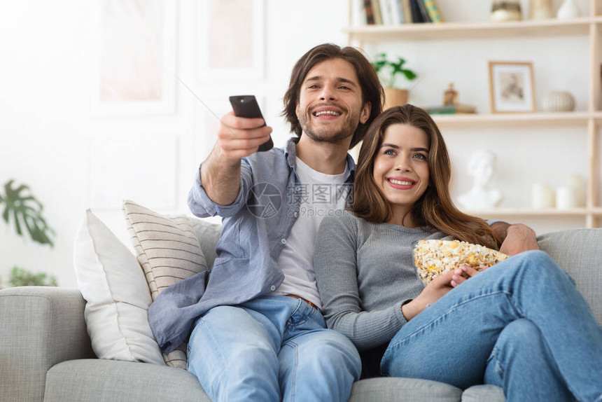 在家看电视爱情侣在沙发上休息吃爆米图片