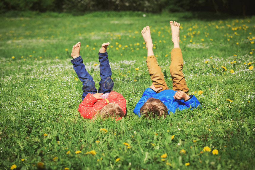 夏天大自然中的小男孩和女孩在绿草上放松图片