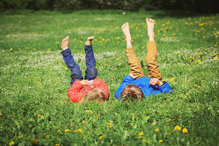 夏天大自然中的小男孩和女孩在绿草上放松图片