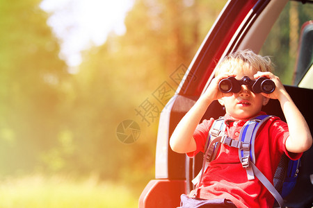 小男孩透过望远镜看小男孩乘车旅行图片