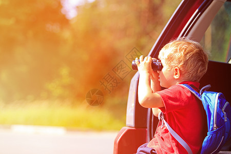 小男孩透过望远镜看小男孩乘车旅行图片