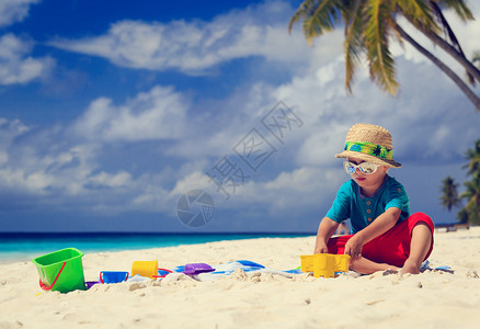 在热带沙滩上玩耍的小男孩图片