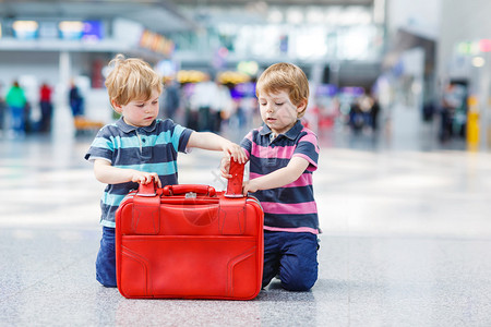 两个小兄弟玩得开心和去度假旅行在机场室内带手图片