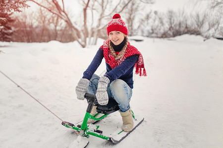 快乐的年轻女子骑雪车图片