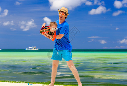 在热带海滩玩耍的父子图片