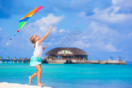 小快乐女孩在热带海滩玩风筝图片