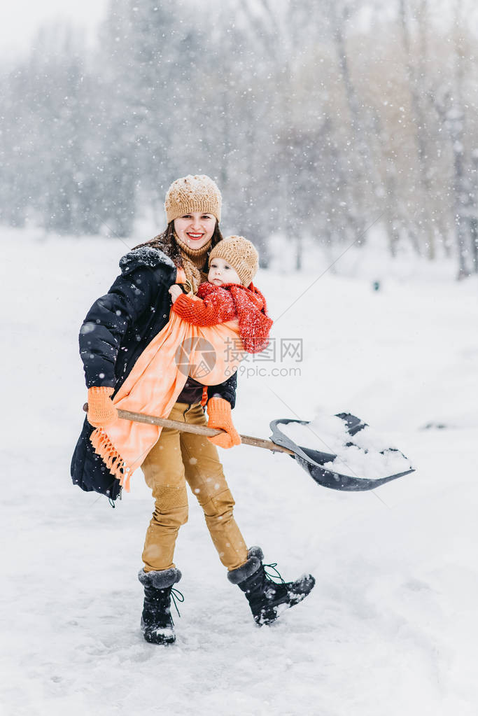 冬天在公园里玩耍的可爱家庭一个孩子和她母亲图片